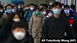 Personas caminan entre una estación del metro y otra en plena hora pico de la mañana en Beijing el martes 20 de diciembre de 2022.