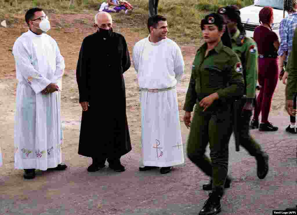 Sacerdotes católicos observan la peregrinación de San Lázaro al Rincón este 17 de diciembre, en la que también estuvieron presentes soldados boinas negras de las Tropas Especiales del Ministerio del Interior. (Yamil Lage-/ AFP)