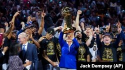 El propietario de los Denver Nuggets, Stan Kroenke sostiene el Trofeo del Campeonato de la NBA después de la victoria del equipo sobre el Miami Heat. (AP/Jack Dempsey)