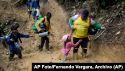 Migrantes con niños atraviesan la selva del Darién rumbo a Panamá en su ruta hacia Estados Unidos, el 15 de octubre de 2022. (AP Foto/Fernando Vergara, Archivo).