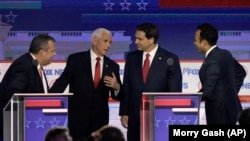 El exgobernador de Nueva Jersey, Chris Christie, el exvicepresidente Mike Pence, el gobernador de Florida, Ron DeSantis, y el empresario Vivek Ramaswamy conversan durante el receso del primer debate de las primarias presidenciales republicanas. 