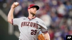 Merrill Kelly, abridor de los Diamondbacks de Arizona, hace un lanzamiento en el segundo juego de la Serie Mundial ante los Rangers de Texas. (AP Foto/Brynn Anderson)