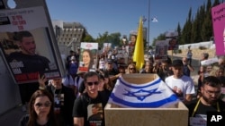 Hagit y Ruby Chen (izq) llevan un féretro vacío en simulacro de procesión fúnebre para israelíes cuyos restos están retenidos por el grupo palestino Hamás en la Franja de Gaza, el 9 de mayo de 2024. (Foto AP/Ohad Zwigenberg)