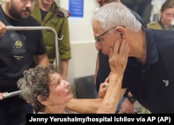 En esta imagen, proporcionada por el hospital Ichilov, Yocheved Lifshitz, una de las dos mujeres liberadas por Hamás el 23 de octubre de 2023, saluda a otra persona en el centro, en Tel Aviv, Israel. (Jenny Yerushalmy/hospital Ichilov vía AP)