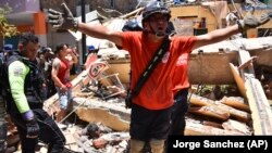 Varios socorristas buscan sobrevivientes entre los escombros tras la caída de un inmueble por un fuerte sismo en Machala, Ecuador, el sábado 18 de marzo de 2023. (AP Foto/Jorge Sanchez)