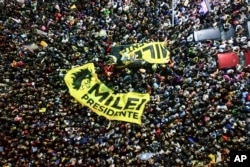 Seguidores del candidato Javier Milei se reúnen afuera de su comando de campaña después de que el aspirante oficialista, Sergio Massa, reconoció su derrota en el balotaje presidencial en Argentina. (AP Foto/Matías Delacroix)