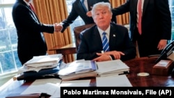 El expresidente Donald Trump en una imagen de archivo, sentado en su escritorio, en la oficina oval de la Casa Blanca, el 8 de febrero de 2017. (AP/Pablo Martinez Monsivais, File)