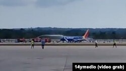 El avión accidentado, en la pista del aeropuerto José Martí de La Habana, mientras los bomberos apagan el fuego en la turbina. (Captura de video/14ymedio)