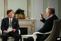 El presidente ruso, Vladímir Putin (d), durante una entrevista con el ex presentador de Fox News Tucker Carlson en el Kremlin. Moscú, 2 de febrero de 2024