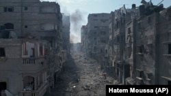 Escombros cubren una calle entre edificios en llamas afectados por un ataque aéreo israelí en Jabaliya, Franja de Gaza, el miércoles 11 de octubre de 2023. (Foto AP/Hatem Moussa)