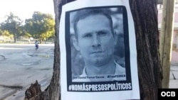 Un cartel pegado a un árbol en una calle de Santiago de Cuba exige la libertad de José Daniel Ferrer y de todos los presos políticos cubanos.