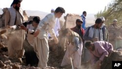 Hombres afganos buscan víctimas tras varios sismos en el distrito de Zenda Jan, en la provincia de Herat, en el oeste de Afganistán, el domingo 8 de octubre de 2023. (AP Foto/Omid Haqjoo)