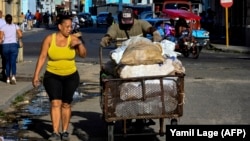 Un hombre empuja una carretilla con sacos de alimentos por una calle de La Habana. (Yamil Lage/AFP)