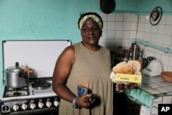 María de los Ángeles Pozo, en su cocina, con algunos de los alimentos que recibió por la libreta de abastecimiento, en La Habana.