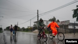 Foto de archivo.La gente se traslada en bicicleta y a pie bajo la lluvia antes de la llegada del huracán Ian en Coloma, Cuba, el 26 de septiembre de 2022. REUTERS/Alexandre Meneghini