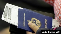 Una persona sostiene su pasaporte cubano antes de subir a un vuelo.(Julio Cortez/AP) 