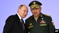 El presidente ruso VLadimir Putin y el ministro de Defensa Serguéi Shoigu asisten a la apertura de una conferencia de seguridad en las afueras de Moscú el 15 de agosto del 2022. (Sputnik, Kremlin Pool Foto via AP)