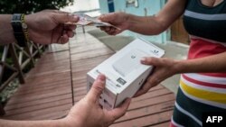 Una mujer compra un equipo para conectarse a la red. AFP