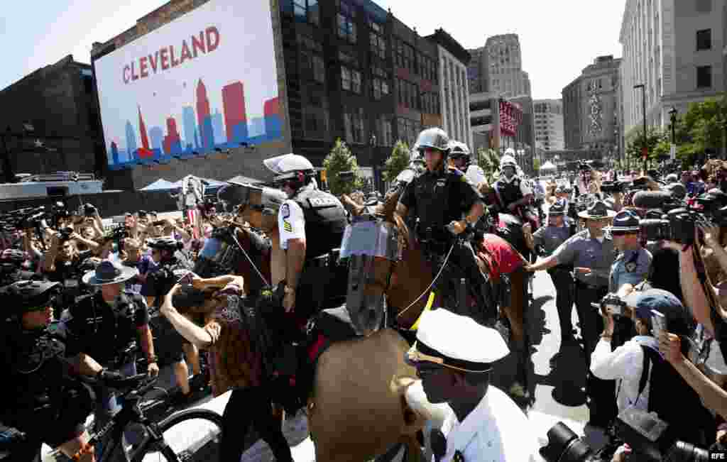 Un grupo de policías intenta despejar la entrada a Quicken Loans Arena, sitio donde se realiza la Convención Nacional Republicana.