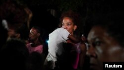 Una madre con su hijo en brazos protesta frente a la sede del Partido Comunista en La Habana, el 29 de septiembre de 2022. (REUTERS/Alexandre Meneghini)