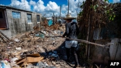 Una mujer camina por una calle llena de escombros en La Coloma, provincia de Pinar del Río, Cuba, tras el paso del huracán Ian. (Yamil Lage/AFP).