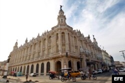 Varios bicitaxis pasan frente al gran Teatro de La Habana "Alicia Alonso".