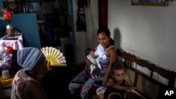 Madre abanica a su hija durante el apagón en Regla, La Habana. (Foto AP/Ramón Espinosa)