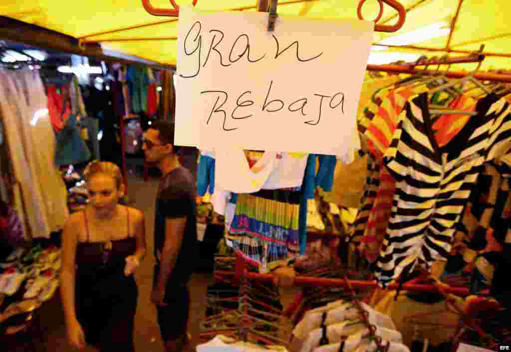 Detalle de un letrero que anuncia rebajas en una tienda de ropa importada ofertada por comerciantes privados.