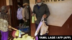 FOTO ARCHIVO. Un hombre sostiene unas botellas de leche en Batabanó, Mayabeque, el 19 de enero de 2022.