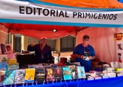 El autor, a la derecha, posa en el stand de la Feria del Libro.