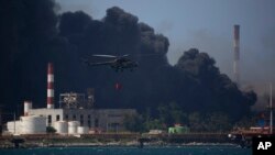 Helicópteros vierten agua sobre los tanques incendiados en la Base de Supertanqueros de Matanzas. (AP Photo/Ismael Francisco)