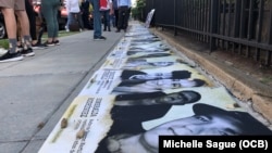 Los rostros de los presos del 11J, en una vigilia por el aniversario de las protestas, en Washington, DC.