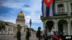 Oficiales de policía caminan cerca del Capitolio, sede de la Asamblea Nacional, en La Habana. (YAMIL LAGE / AFP)