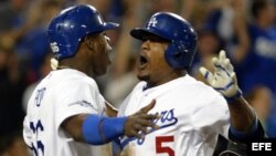 El jugador de los Dodgers de Los Ángeles, el dominicano Juan Uribe (d), es felicitado por su compañero de equipo, el cubano Yasiel Puig (i) después de batear un imparable e impulsar dos carreras contra los Bravos de Atlanta, el lunes 7 de octubre de 2013.