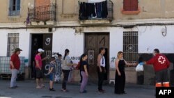 Un grupo de personas hace fila para recibir alimentos distribuidos por la Cruz Roja en Valencia el pasado 20 de abril. JOSE JORDAN / STR / AFP