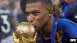 El delantero francés Kylian Mbappé besa el trofeo tras vencer a Croacia en la final del Mundial de Fútbol de Rusia 2018.