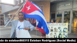 El periodista Esteban Rodríguez, con un cartel exigiendo la libertad de Ferrer, detrás Anamely Ramos exigiendo la de varios presos políticos.