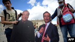 Votantes sostienen carteles con las imágenes de los candidatos presidenciales Gustavo Petro y Rodolfo Hernández. (Raul ARBOLEDA/AFP)