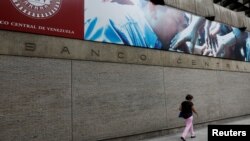 Una mujer camina frente al Banco Central de Venezuela, en Caracas. (Archivo)