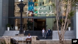 Foto Archivo. Trabajadores en la entrada del Hotel Packard. AP Photo/Desmond Boylan