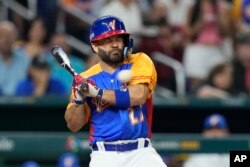 El venezolano José Altuve es golpeado por un lanzamiento durante la quinta entrada del juego de béisbol en el Clásico Mundial de Béisbol en contra de Estados Unidos, el sábado 18 de marzo de 2023, en Miami. (AP Foto/Wilfredo Lee)