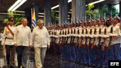 El presidente cubano Raúl Castro (i) y el presidente de Uruguay José Mujica (d) pasan revista a la guardia de honor en el Palacio de la Revolución en La Habana (Cuba). 