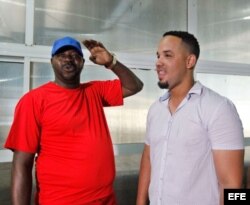 El exbeisbolista cubano Pedro Luis Lazo (i) conversa con el primera base de los Medias Blancas de Chicago, José Abreu (d) durante una clase práctica a niños cubanos el 16 de diciembre de 2015, en La Habana (Cuba).