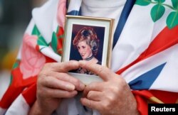 Un seguidor de la corona sostiene una foto de la princesa Diana en el 25 aniversario de su muerte, frente a Kensington Palace, en Londres, en agosto pasado. (REUTERS/Peter Nicholls)