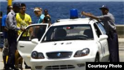 Policías detienen a un joven en el malecón habanero.