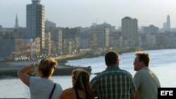 Un grupo de turistas observan La Habana, al atardecer, desde la fortaleza de El Morro, al otro lado de la bahía