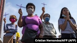 Venezolanos oran en medio de la pandemia de COVID-19.