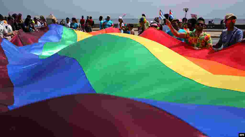 Cientos de personas ondean una gigante bandera de la comunidad LGBTI durante una "conga" contra la homofobia y la transfobia en La Habana.