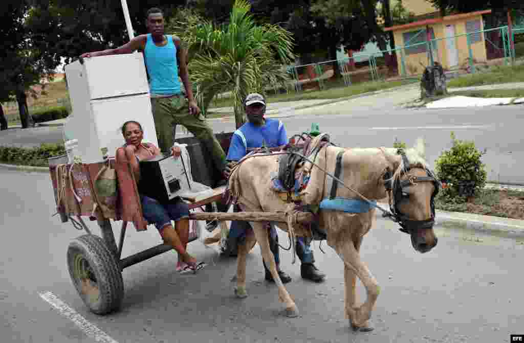 Una familia se dirige con sus pertenencias a un lugar seguro hoy, lunes 03 de octubre de 2016, en la ciudad de Guantánamo (Cuba), ante la proximidad del huracán Matthew. Seis provincias de Cuba se encuentran bajo "alarma ciclónica" a la espera del potenci