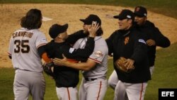 El lanzador de Gigantes Madison Bumgarner (c) celebra con sus compañeros la victoria sobre Reales.